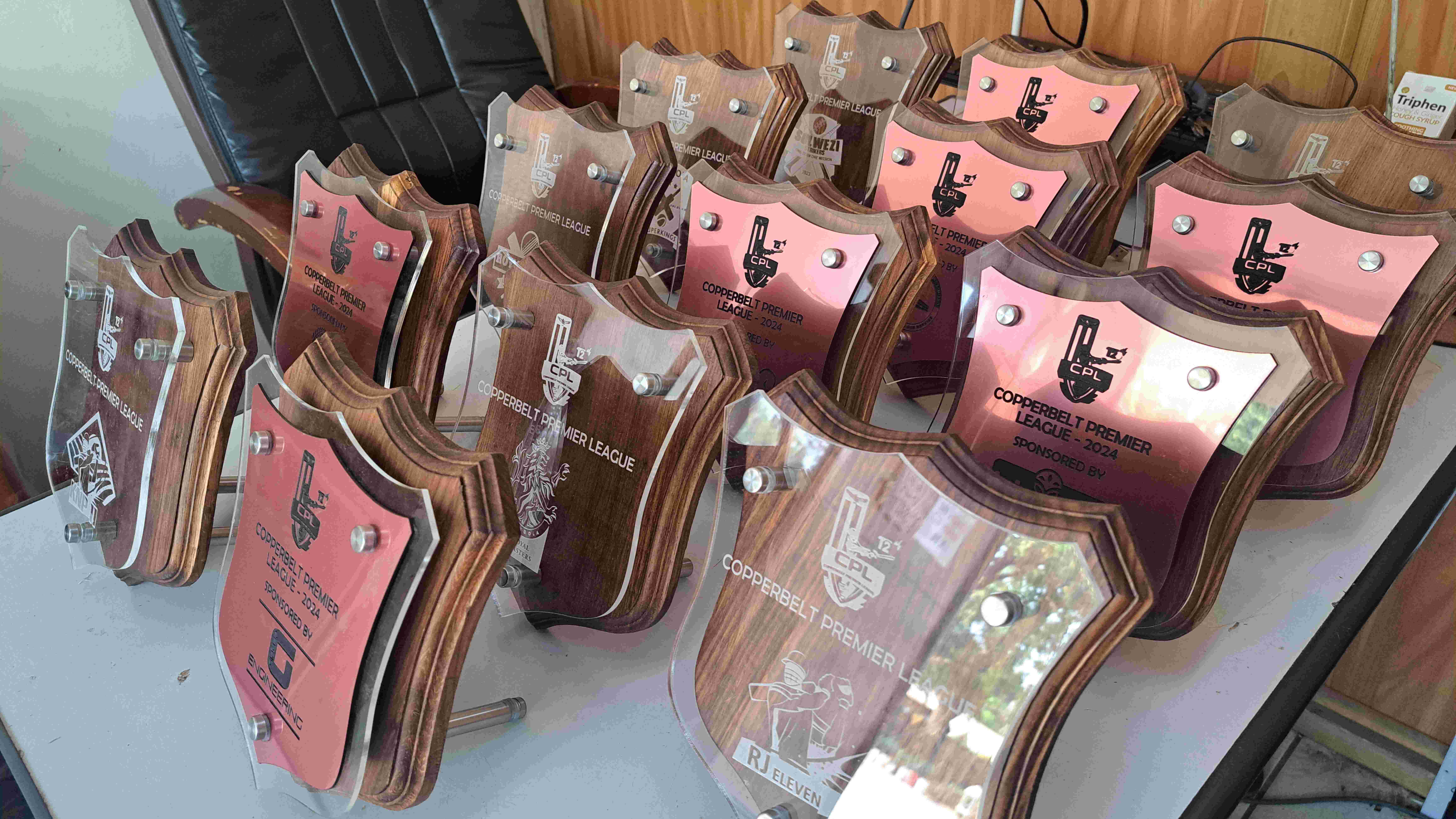 Laser-cut wooden shield plaques with engraved acrylic and copper faces for the 2024 Copperbelt Premier League