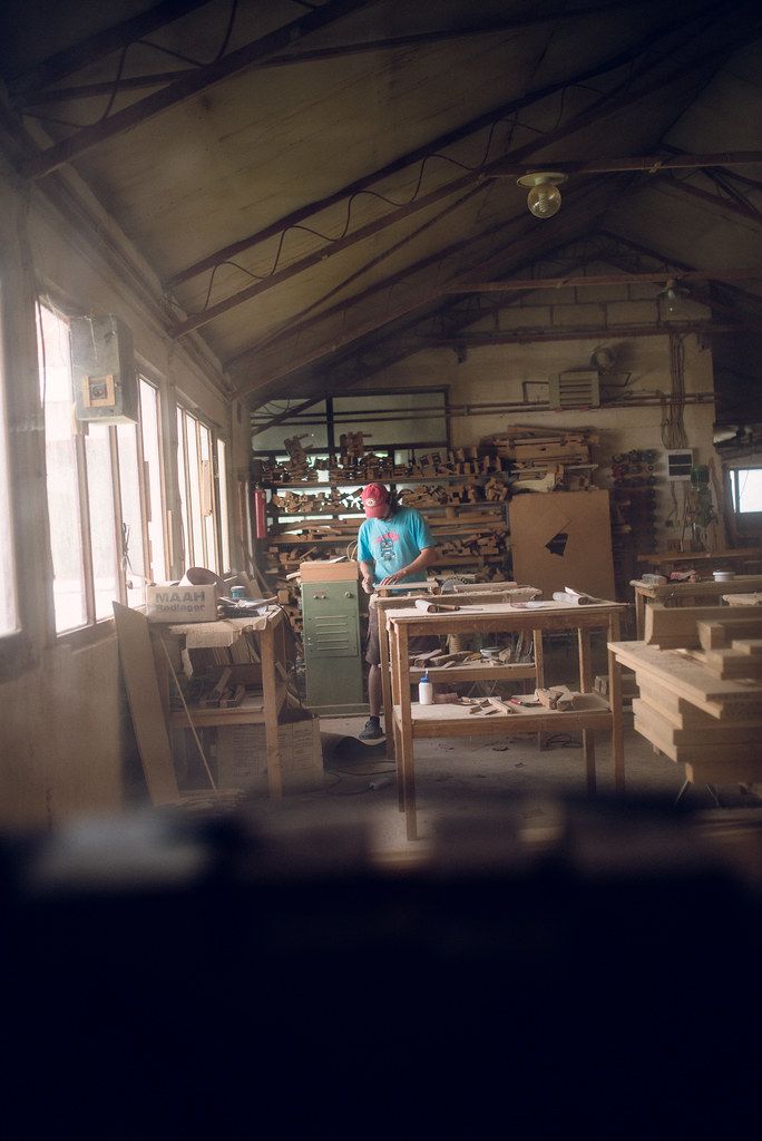 A furniture workshop interior with workbenches and timber